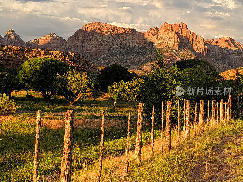 犹他州洛克维尔的格拉夫顿路(Grafton Road)栅栏上的晚霞和锡安国家公园(Zion National Park)守望者峰上的晚霞